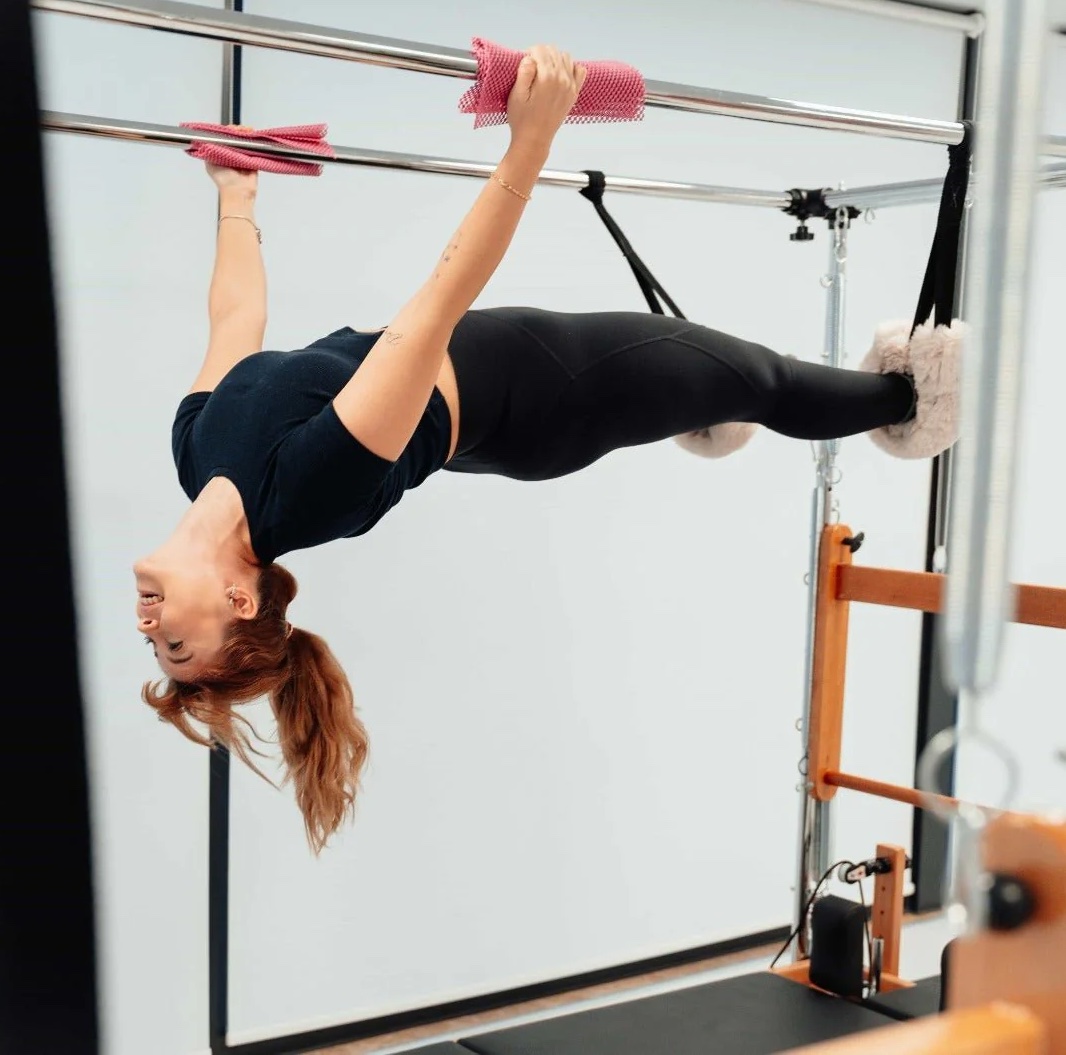 Clinical Pilates setup using a Reformer and Cadillac for graded exposure to neck movement and multi-planar stability in a low-gravity environment.
