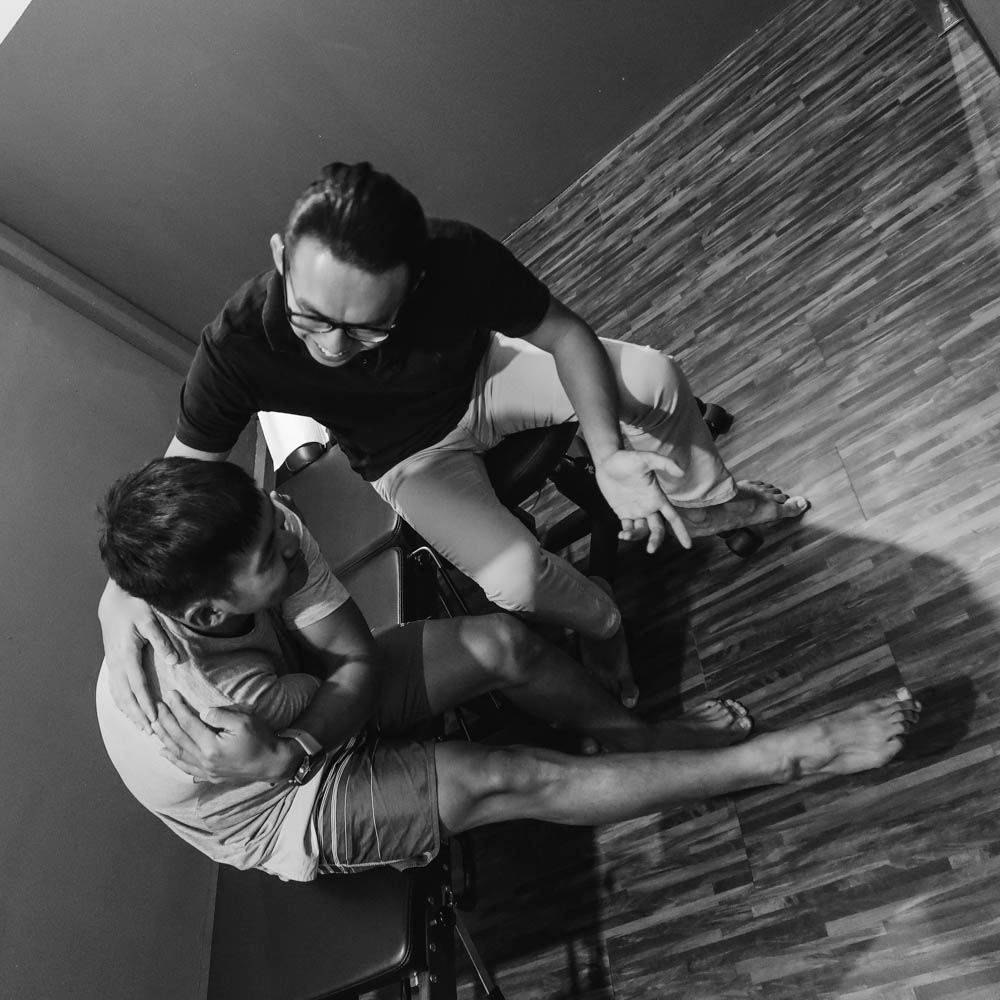 A chiropractor explaining modern pain science to a patient to reduce dependency on unnecessary medical treatments