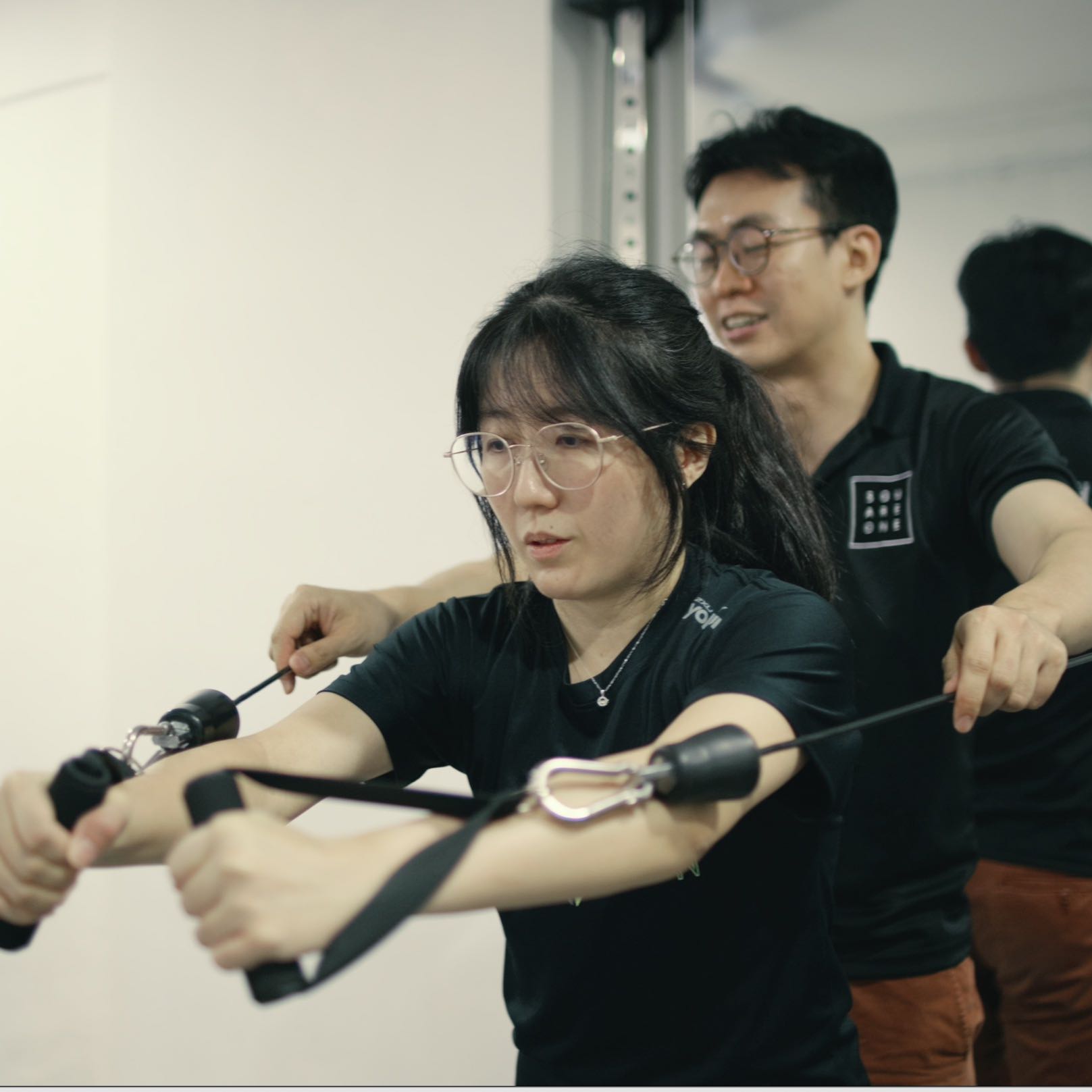 Resistance training equipment including a cable machine and squat rack used to increase absolute cervical strength and build a muscular buffer for desk professionals.
