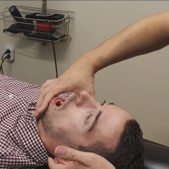 A clinical demonstration of a passive jaw adjustment, showing why manual manipulation of the TMJ fails to build the necessary muscular capacity for long-term jaw stability.