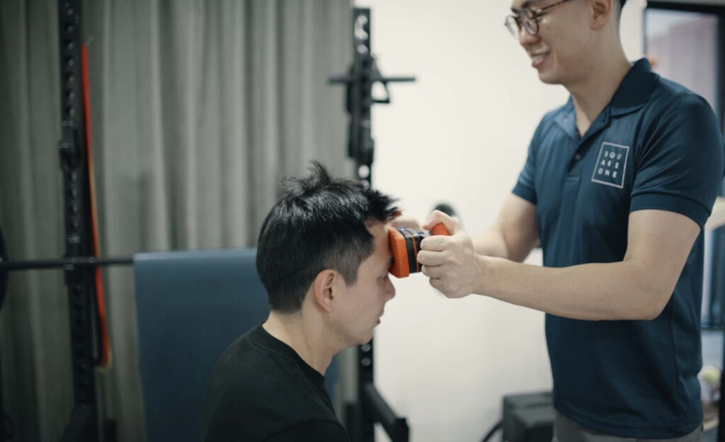 Chiropractor Jesse Cai measuring deep neck flexor strength with a dynamometer to assess cervical muscle function in a neck pain patient.