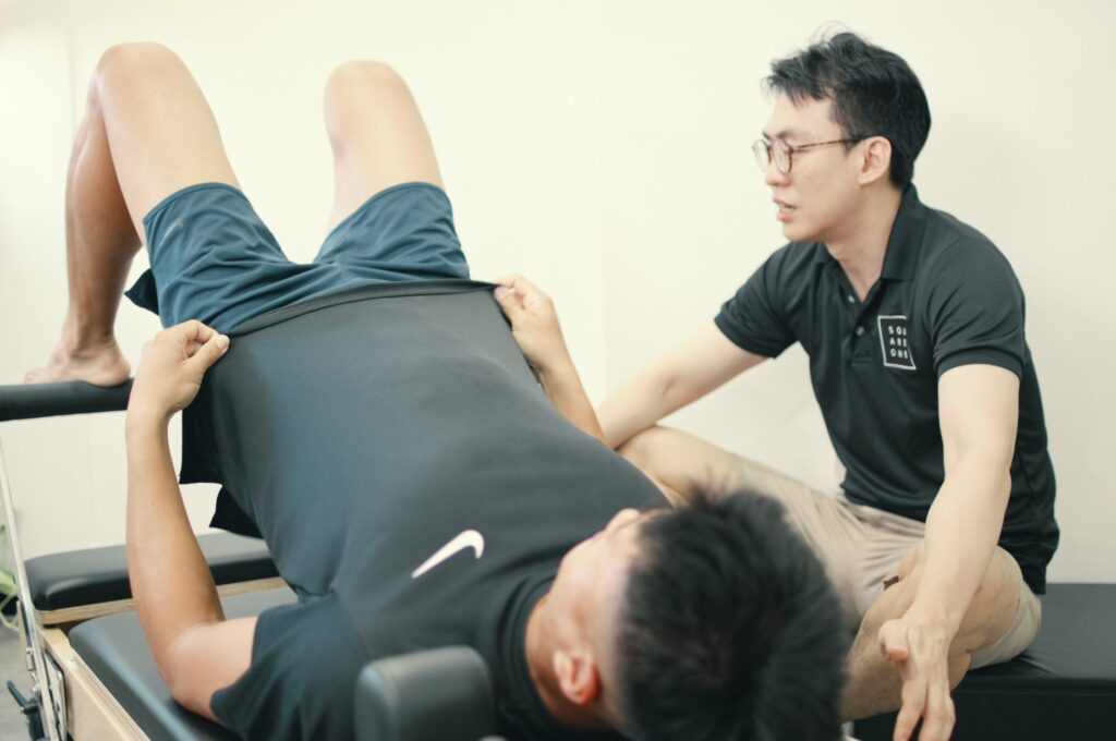 Client performing evidence based Clinical Pilates on a reformer for low back pain recovery at Square One Active Recovery Singapore