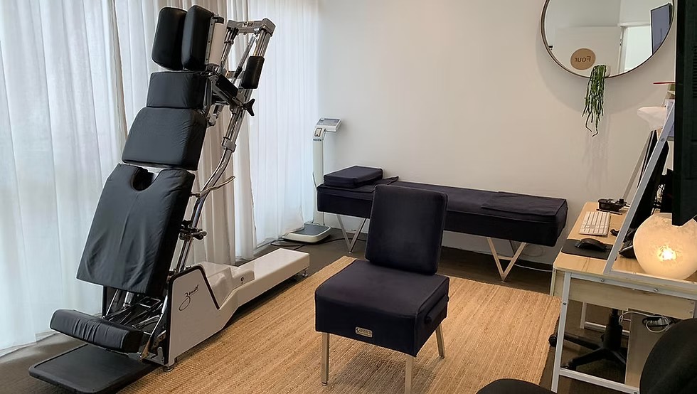 Specialised Gonstead chiropractic adjustment table and cervical chair inside a Singapore clinic