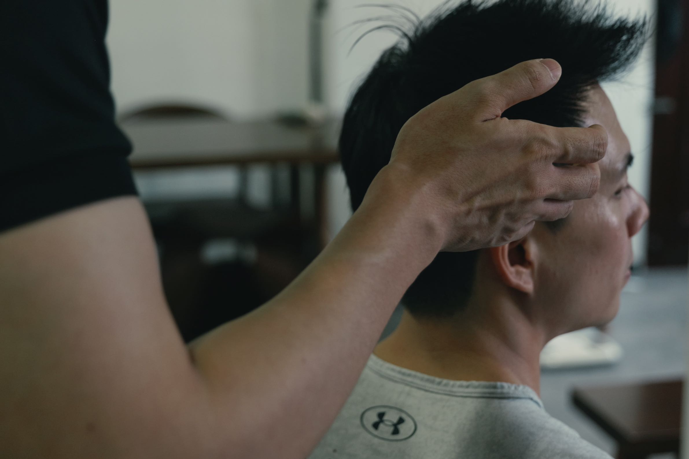 Knee Pain MRI Singapore: When You Actually Need One (2026 Guide) - Square One Active Recovery Chiropractor Jesse Cai performing a cervical range of motion assessment on a patient to evaluate joint stability and identify the root cause of neck pain.