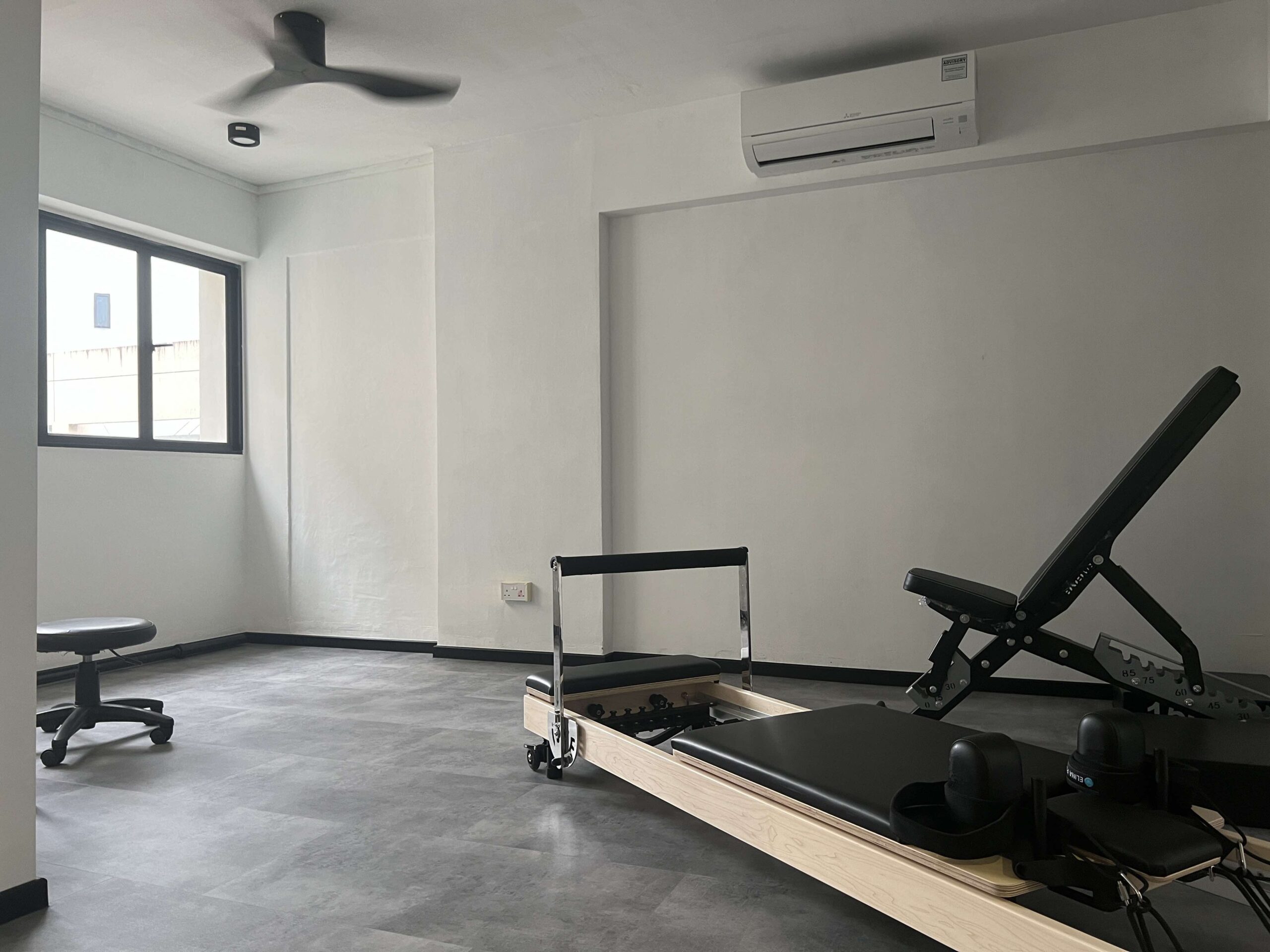 A modern home Pilates reformer setup inside a bright Singapore condominium living room