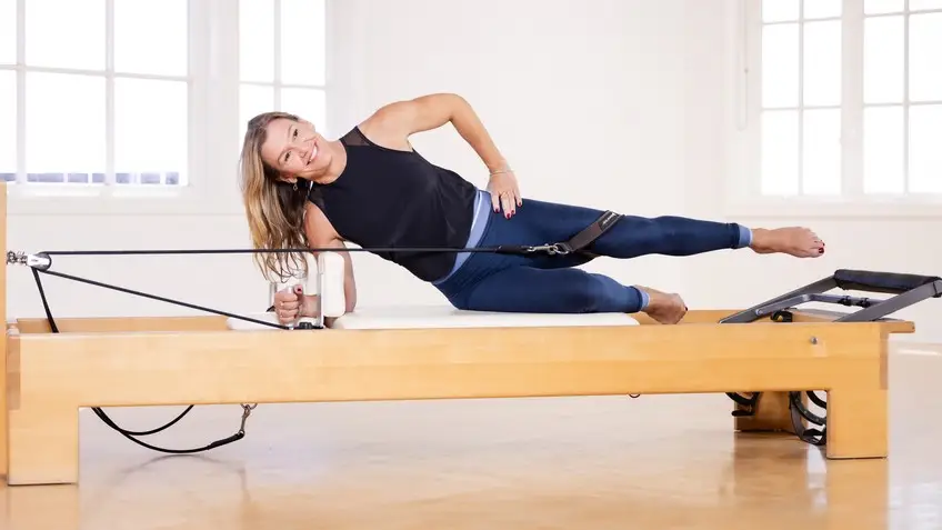 Reformer Pilates exercise using straps to improve joint centration and proprioception.