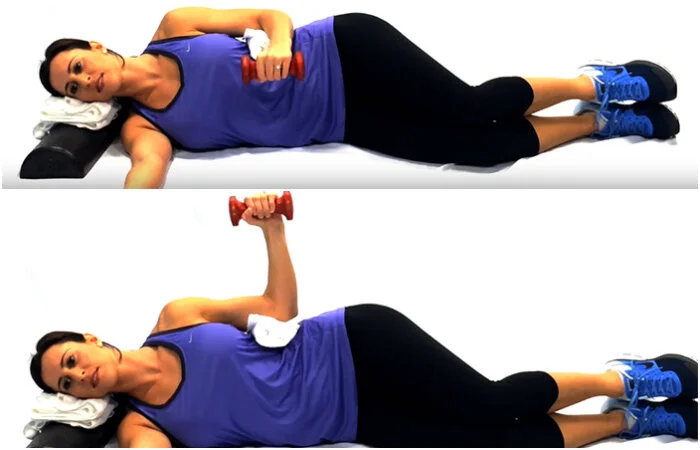 Woman performing side-lying rotator cuff exercise in Singapore clinic to improve dynamic shoulder joint centration.